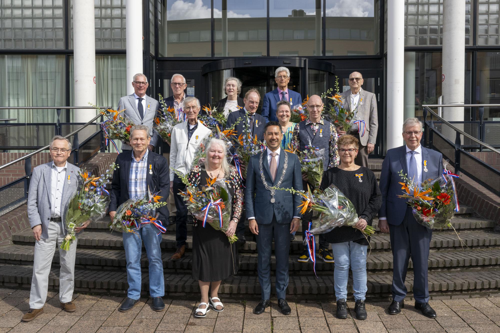 Groepsfoto van burgemeester Bergmann met alle gedecoreerden.