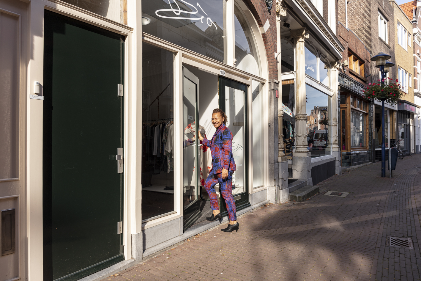"Foto van een winkelier op de Hoogstraat in Schiedam"