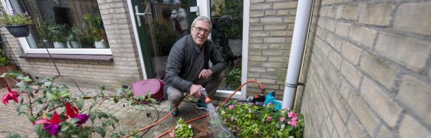 Henk gebruikt regenwater om zijn tuin te sproeien
