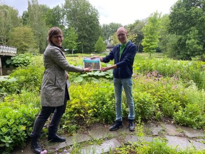 "Marjet van Arkel (gemeente Schiedam) overhandigt het beheerplan aan Leon Collignon (Stichting Vrienden van Beatrixpark Schiedam)."